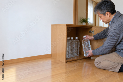 Man storing bottled water at home for emergency preparedness