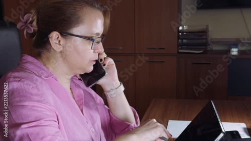 Busy Businesswoman Multitasking with Phone and Laptop in Office
