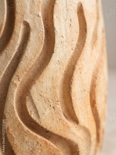 Macro close-up of sculpted wavy terracotta or clay vase surface