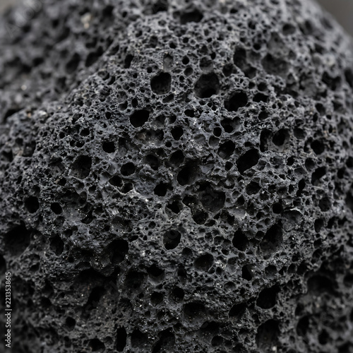 Macro close-up of dark porous volcanic basalt lava stone texture
