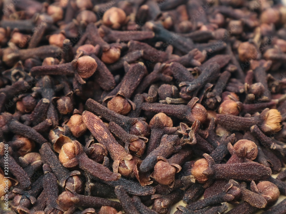 Fototapeta premium Close up top view of dried cloves spice background texture. Organic aromatic culinary ingredient, traditional herbal medicine, and natural raw spice for cooking, baking, and flavoring