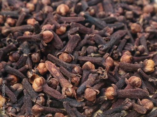 Close up top view of dried cloves spice background texture. Organic aromatic culinary ingredient, traditional herbal medicine, and natural raw spice for cooking, baking, and flavoring 