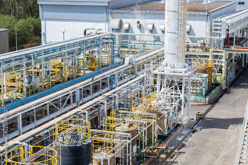 Row of large industrial cooling towers with fan motors at manufacturing plant