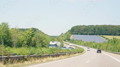 Highway curve with cars and solar farm slow motion road trip