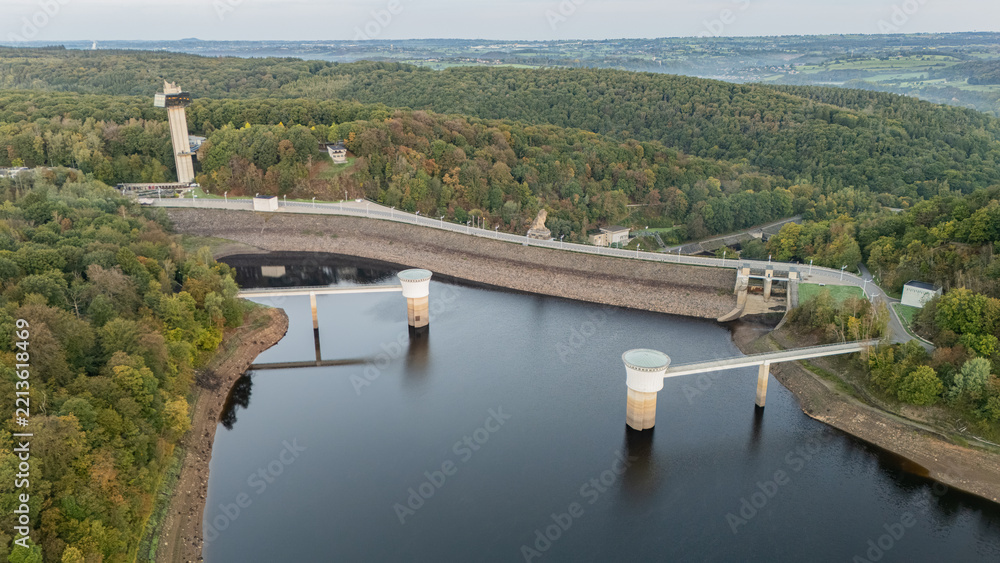 Obraz premium Gileppe Dam and reservoir surrounded by autumn forest, aerial view