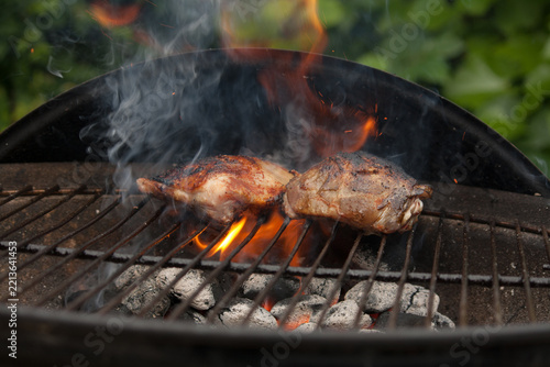 Chicken breast laying in the flames on barbecue