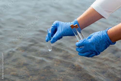 scientist gloved hands collecting water sample test tubes lake river surface microplastic pollution testing environmental research concept of ecology contamination science