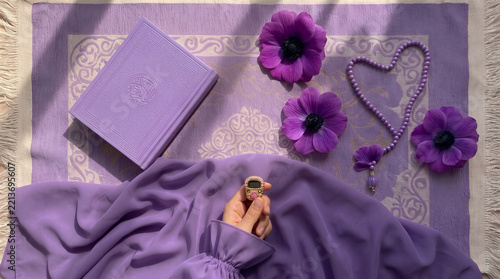 Ramadan prayer mat with holy book prayer beads and purple flowers for