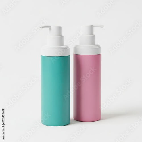 Two cosmetic pump bottles in turquoise and pink colors on white background