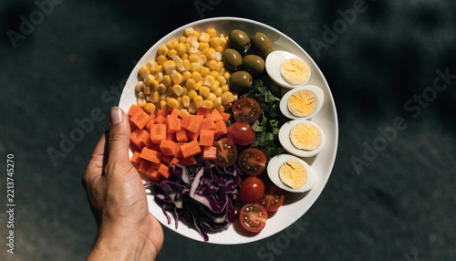 Hand Holding a Bowl of Fresh Salad