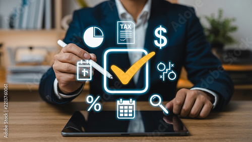 Businessman using a stylus on a tablet to select digital tax and