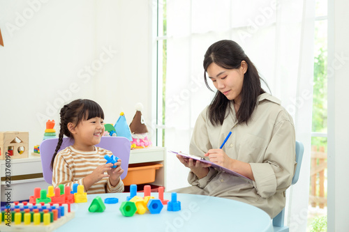 Asian Woman Assessing Child Development Through Educational Play and Learning Activities