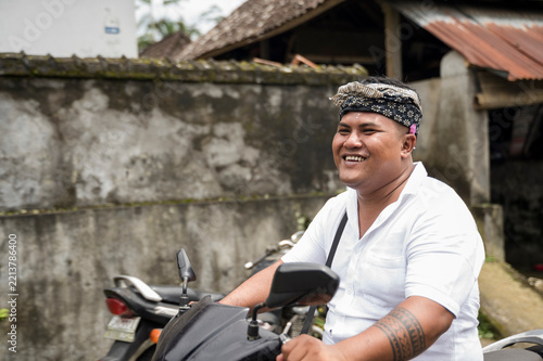 Balinese man on motorbike wearing traditional udeng headwear