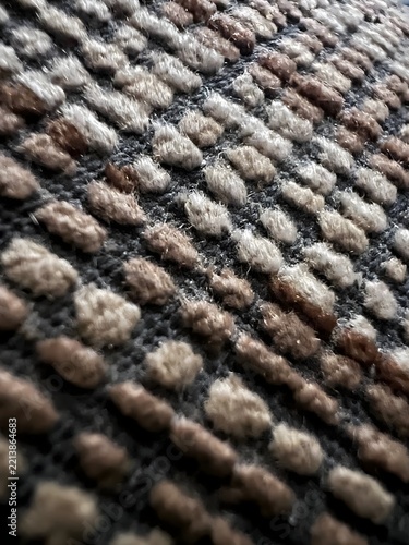 Textura de tejido con relieve en tonos beige, marrón y gris oscuro, detalle macro.