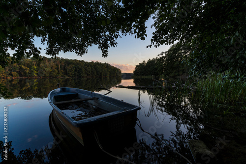 Sunset on the shore of calm lake.