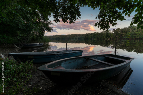 Sunset on the shore of calm lake.