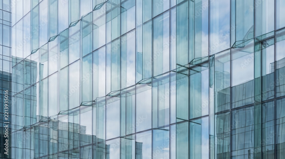 Obraz premium Modern glass skyscraper facade with sky and cloud reflection pattern