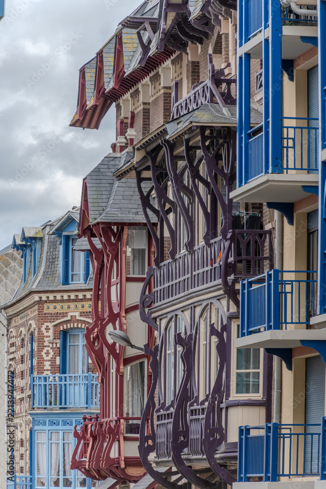 Fototapeta premium Houses of Mers-les-Bains, seaside town with 19th-century sea-bathing villas with colorful wooden balconies and white chalk cliffs, tourists destination in France