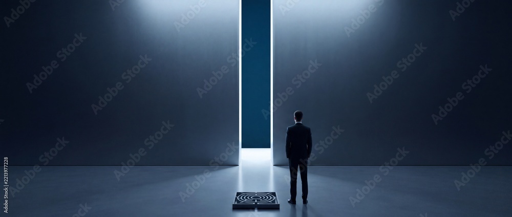 Fototapeta premium Ambitious Businessman Standing Before a Giant Wall with a Narrow Path of Light and a Maze on the Floor, Conceptual Metaphor for Finding Solutions, Career Growth, and Overcoming Complex Challenges