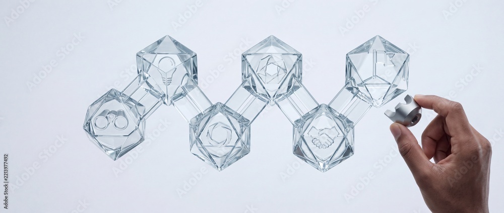 Fototapeta premium Conceptual Business Strategy and Success Journey Showing Glass Geometric Nodes with Icons of Vision Idea Partnership and Achievement Being Assembled by Human Hand on White Background