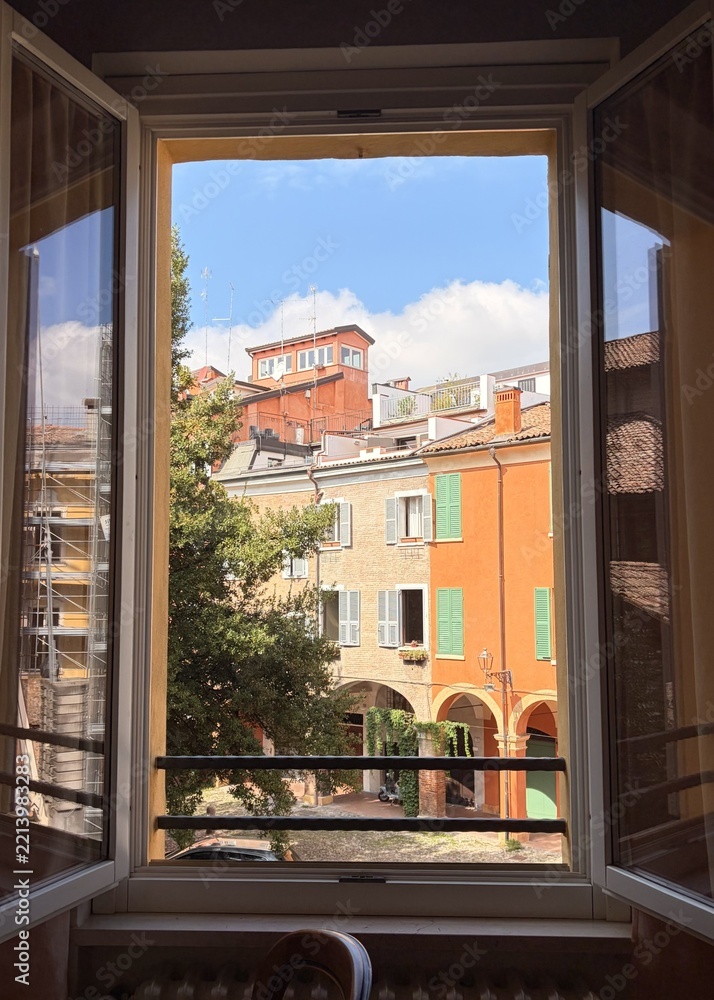 Fototapeta premium Scenic view of cozy Italian alleyway and old architecture from a residential window in Modena
