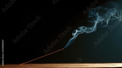 A nearly burned incense stick with a thin, straight line of rising smoke.