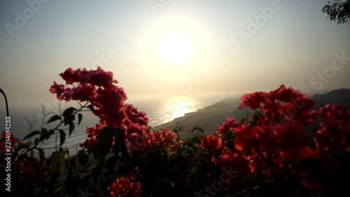 A beautiful late-afternoon panorama reveals the silhouettes of coastal hills and sunlight reflecting off the surface of the Indian Ocean the dramatic sunset at Parangtritis Beach