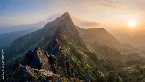 Majestic Mountain Ridge at Sunrise with Dramatic Mist and Golden Sunlight Over Lush Green Slopes and Rocky Peaks in a Serene Wilderness Landscape