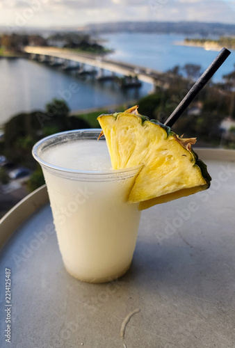 Tropical Pina Colada Cocktail with Pineapple Slice and Scenic Ocean View
