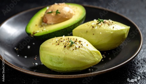 Freshly Prepared Avocado Halves with Herbs and Spices on Dark Plate