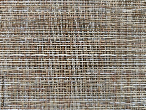 Woven texture background of a brown and beige mat, bamboo placemat, gunny sack cloth or wicker furniture, perfect as a neutral eco-friendly backdrop.