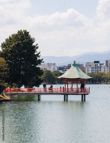 Ohori Park panorama in Fukuoka, Japan, Chuo-ku ward, Kyushu island, with pond, Ukimi-do pavilion, swan boats, bridges and city skyline near Maizuru Park, lake and promenade in a spring sunny day