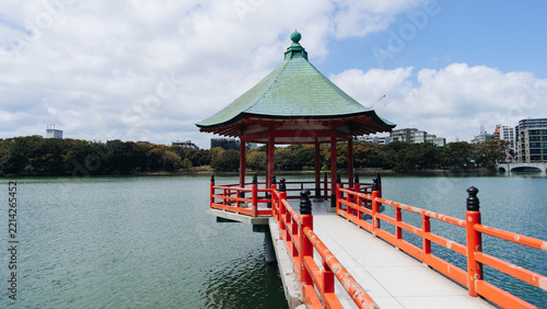 Ohori Park panorama in Fukuoka, Japan, Chuo-ku ward, Kyushu island, with pond, Ukimi-do pavilion, swan boats, bridges and city skyline near Maizuru Park, lake and promenade in a spring sunny day