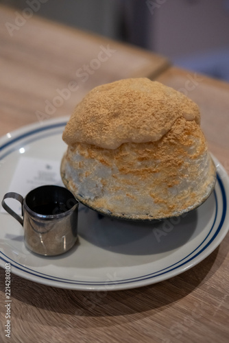 Japanese style milky shaved ice topped with chewy mochi pieces and dusted with kinako roasted soybean flour.