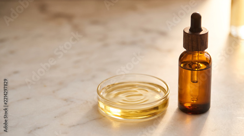 Amber dropper bottle with essential oil on marble surface