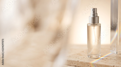 Clear cosmetic spray bottle on stone surface with prism light