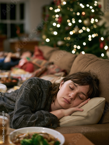 Young woman sleeping on sofa after holiday dinner