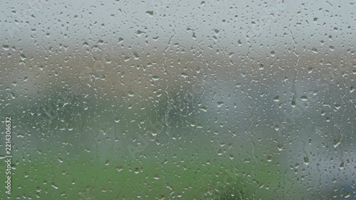 Rain drop hitting window glass and sliding down