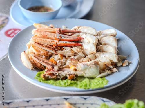 Steamed crab meat and crab claws served on a plate with dipping sauce