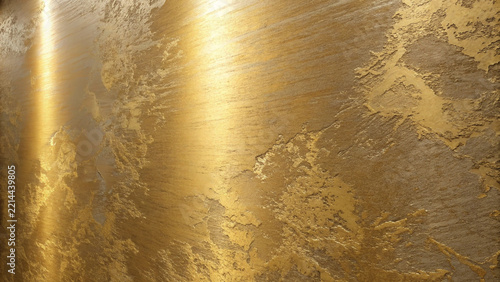 Textured golden wall surface with dramatic side lighting creating abstract shimmering patterns