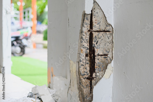 Damaged concrete pillar exposing rusted rebar steel inside