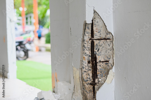 Damaged concrete pillar exposing rusted rebar steel inside
