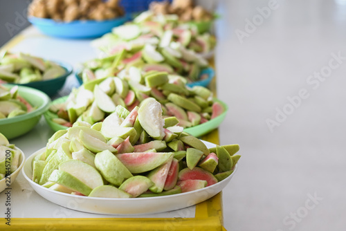 Sliced fresh pink-fleshed guava served on white plates