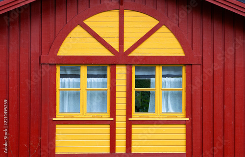 Title:
Traditional red and yellow wooden house facade with windows in Norway
