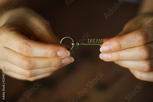 Obraz na plátně Hands Holding Antique Key with 'Dream' Inscription Representing Aspirations and