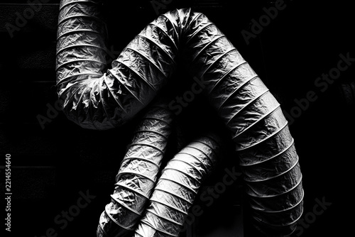 Curved ventilation ducts against darkness in black and white
