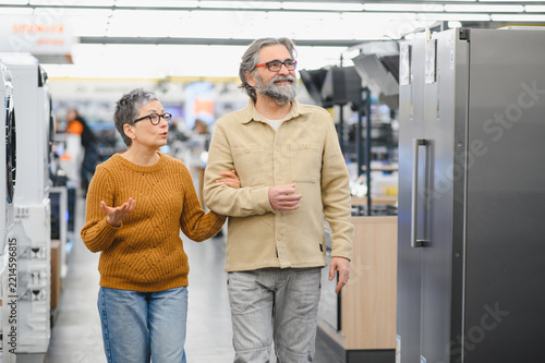 Senior couple choosing refrigerator in appliance store