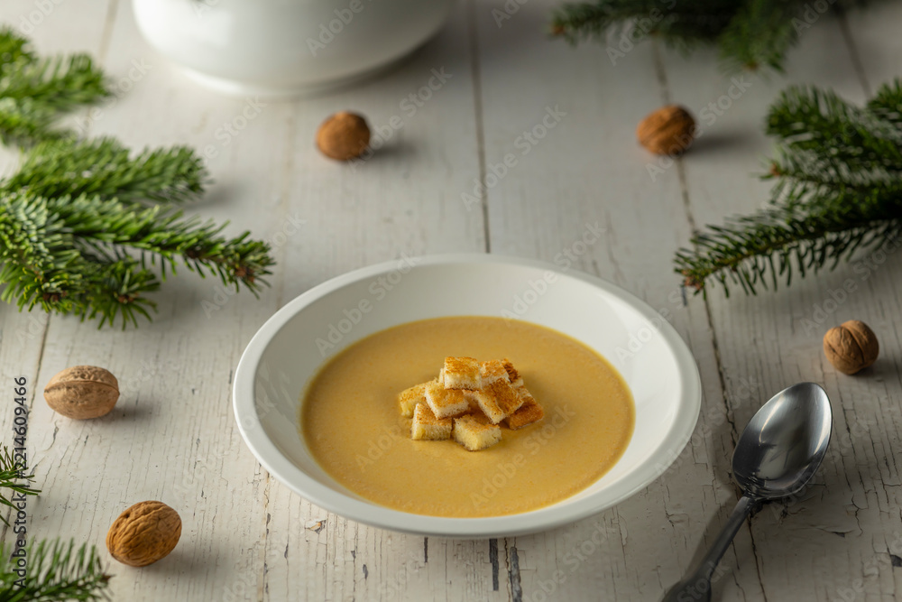 Fototapeta premium Creamy soup with croutons on rustic Christmas table