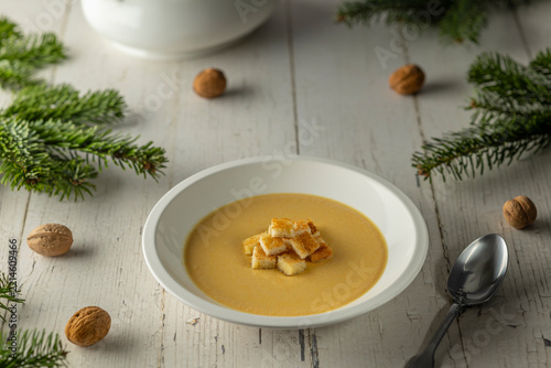 Creamy soup with croutons on rustic Christmas table
