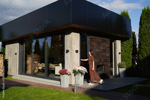 Woman opening door entering modern prefab ADU guest house